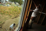 10 September 2012 - Workers install windows in a new home at a construction site only a few hundred metres from the USA border, and Washington State, in Surrey, B.C., Canada. Credit: Adrian Brown - N49Photo.