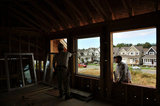 10 September 2012 - Workers install windows in a new home at a construction site only a few hundred metres from the USA border, and Washington State, in Surrey, B.C., Canada. Credit: Adrian Brown - N49Photo.