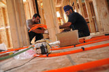 20 September 2012 - Gurgit Nijjar, left, and Ranjit Singh Sandhu install a series of valves on the second floor of a new home, where they will be used in the property's Hydronic Radiant Floor Heating system, at a construction site in Surrey, B.C., Canada. Credit: Adrian Brown - N49Photo.