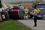 05 November 2012 - The driver of an overturned truck speaks on the phone, beside the scene of the accident on Highway 99, in Surrey, B.C., Canada. While an investigation will take place, it is believed that the right front tire of the truck blew out, causing the truck to veer off the shoulder, rolling onto its side in a grassy area beside the highway. The driver was unhurt at the scene. Credit: Adrian Brown - N49Photo.