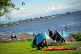 25 September 2013 - White Rock, B.C., Canada - Two men pack up their kiteboard equipment, as others fly their kites and kiteboard on East Beach, on the Semiahmoo First Nation reserve just south of the city of White Rock. Drayton Harbor and the US coastline in Washington State are seen in the distance. Photo Credit: Adrian Brown / Sipa Press.